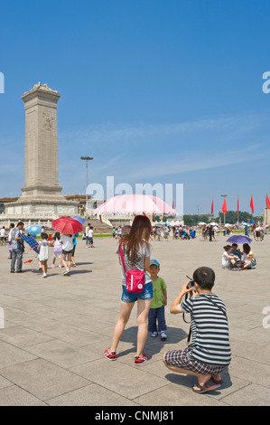 Les touristes chinois de la Place Tiananmen, la prise de photographies de l'autre avec le monument aux héros du peuple et le grand Hal Banque D'Images