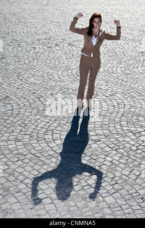 Businessman cheering sur route pavée Banque D'Images