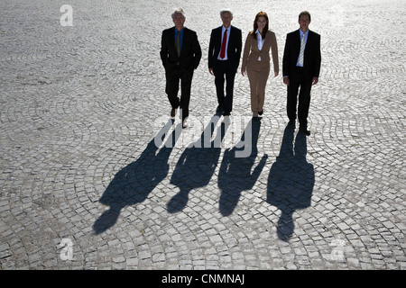 Les gens d'affaires marche sur route pavée Banque D'Images