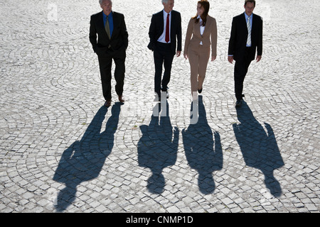 Les gens d'affaires marche sur route pavée Banque D'Images