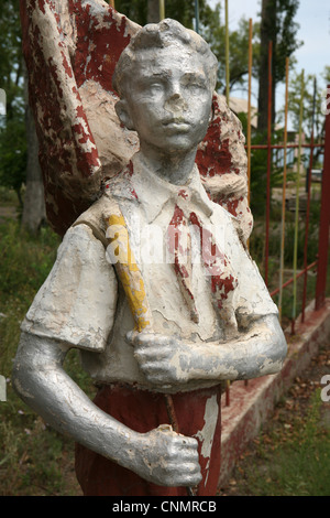 Statue d'un jeune pionnier dans un camp de jeunes abandonnés à Pioneer Barskoon sur le lac Issyk Kul, le Kirghizistan. Banque D'Images