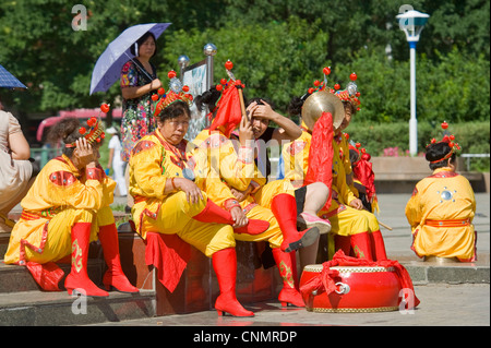 La place de la ville de Chengde avec des femmes dans un groupe de musique traditionnelle et de détente portant des vêtements traditionnels. Banque D'Images