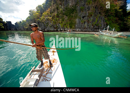 Boatsman dans un outrigger bateau près de la côte de la partie continentale de Palawan, El Nido, Palawan, Philippines, Asie Banque D'Images