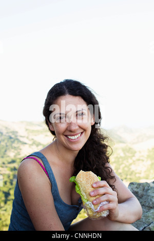 Randonneur eating sandwich sur hill Banque D'Images