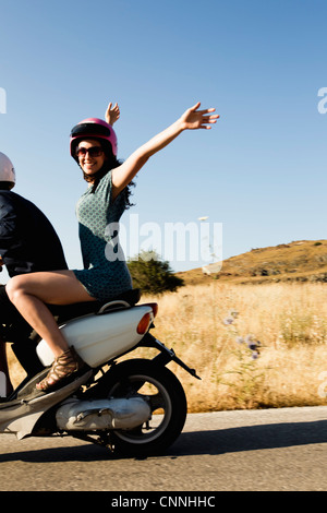 Les femmes au volant un scooter on rural road Banque D'Images