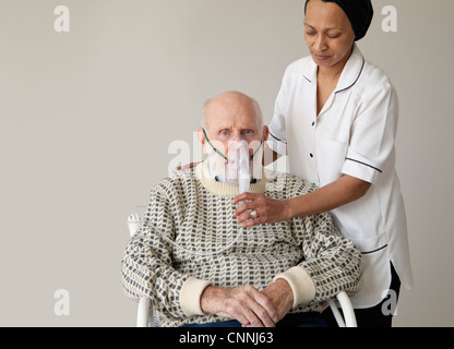 Gardien d'aider l'homme plus âgé avec l'oxygène Banque D'Images