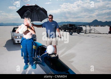 Blue top fuel drag race voiture avec chauffeur femme soleil sous abris de parapluie à la semaine de vitesse de Bonneville Salt Flat Banque D'Images