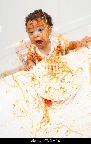 Boy eating Spaghetti aux mains Banque D'Images