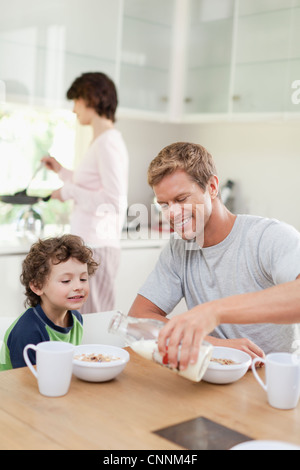 Family eating breakfast in kitchen Banque D'Images