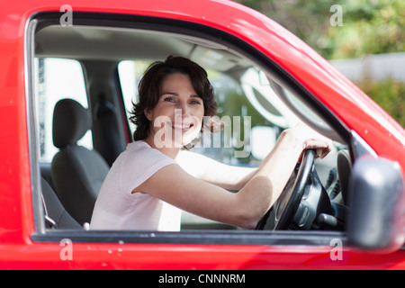 Woman smiling in du conducteur de voiture Banque D'Images