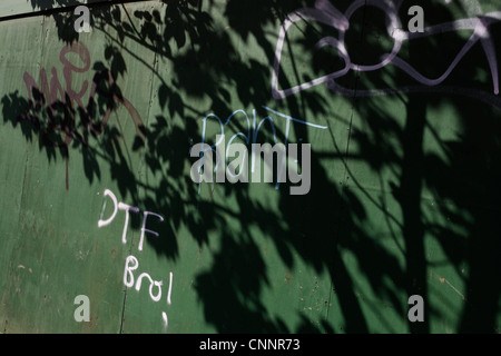 Ombre de l'arbre à proximité sur un chantier de la thésaurisation marqués avec graffiti pour les jeunes dans le sud de Londres. Banque D'Images