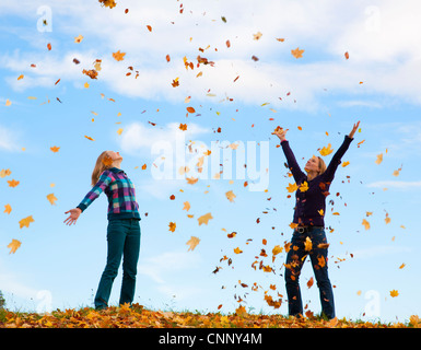 Mère et fille jouer dans les feuilles Banque D'Images