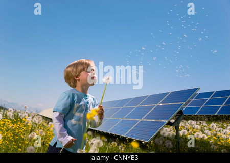 Garçon dans les champs avec des panneaux solaires Banque D'Images