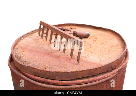 Rusty râteau sur baril rouillé vieux outils de jardin sur fond blanc Banque D'Images