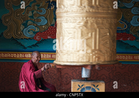 L'Asie, Bhoutan. Vieux moine tourne à prières à l'entrée à Punakha Dzong palace Banque D'Images