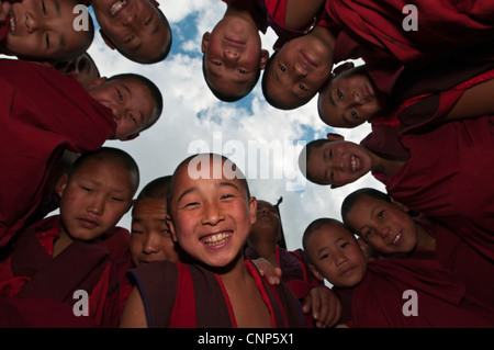 L'Asie, Bhoutan, Paro. Jeunes moines en cercle regarder vers le bas et sourire au monastère Dzong de Paro Banque D'Images