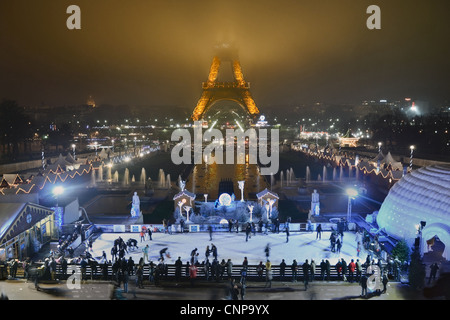 Paris à Noël. Les gens le patin à glace dans la nuit en face de la Tour Eiffel à Paris, France. Banque D'Images