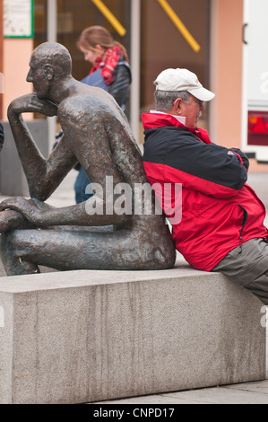 Senior man sitting on park bench Passau, Allemagne. Banque D'Images