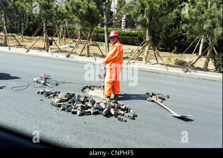 Travailleur chinois à l'aide de marteau pneumatique à road, Qingdao, Chine Banque D'Images