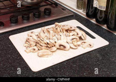 Champignons hachés sur planche à découper blanc Banque D'Images