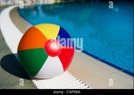 Pose de ballon de plage près de la piscine extérieure Banque D'Images