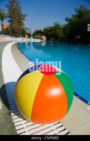 Pose de ballon de plage près de la piscine extérieure Banque D'Images