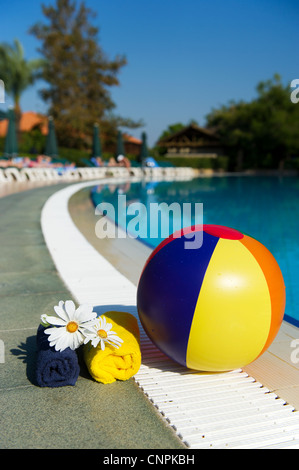 Pose de ballon de plage près de la piscine extérieure Banque D'Images