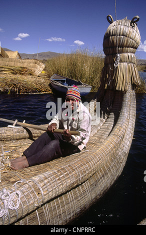 Un bateau d'aviron de l'homme reed sur les îles flottantes Uros. Le lac Titicaca, au Pérou. Banque D'Images