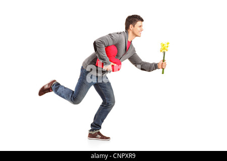 Jeune homme en marche avec un bouquet de fleurs en forme de coeur rouge et l'objet dans ses mains isolé sur fond blanc Banque D'Images