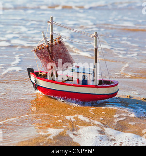 Le petit bateau se trouve sur la plage de sable Banque D'Images