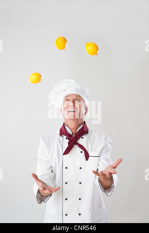 Chef jonglant avec les citrons Banque D'Images