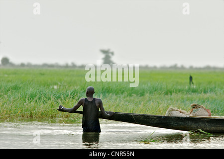 Un homme de patauger dans la rivière à Mopti, au Mali. Banque D'Images