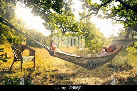 Man relaxing in hammock outdoors Banque D'Images