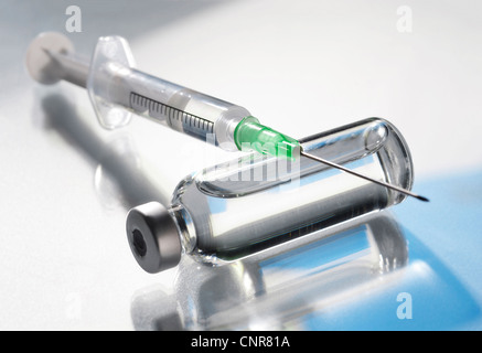 Gros plan d'une seringue et d'élevage flacon de médicaments sur une surface réfléchissante. Banque D'Images