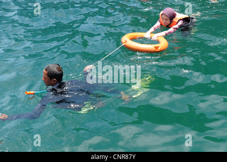 Dame musulmane apprendre à nager, l'île de Koh mook (également connu sous le nom de ko muk) , la mer d'Andaman, Trang, Thaïlande Banque D'Images