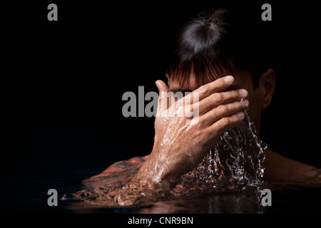 Homme natation en piscine la nuit Banque D'Images