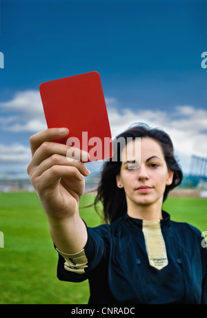 Femme tenant une carte rouge sur le terrain de football Banque D'Images