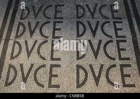 Titre 'Duce' répétées dans la mosaïque de la chaussée au Foro Italico, anciennement Foro Mussolini, à Roma, Italie. Banque D'Images