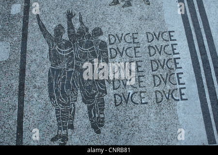 Titre 'Duce' répétées dans la mosaïque de la chaussée au Foro Italico, anciennement Foro Mussolini, à Roma, Italie. Banque D'Images