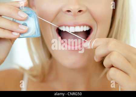 Woman using Dental Floss, cropped Banque D'Images