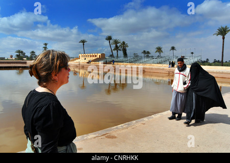 Promenades touristiques de l'Ouest musulmane passé en couple, hijab complet Jardins Menera, Marrakech Maroc Afrique du Nord Banque D'Images