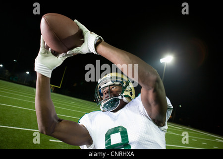 Football player catching ball Banque D'Images
