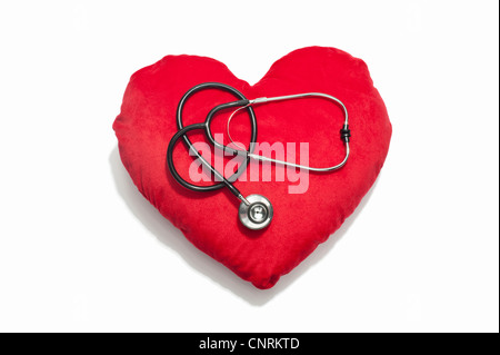 Un stéthoscope sur un coussin en forme de coeur rouge Banque D'Images