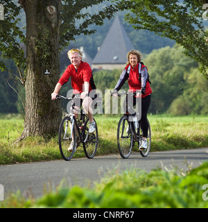 Elder couple à vélo sur la piste cyclable de la vallée de la Ruhr Kemnade, château en arrière-plan, l'Allemagne, en Rhénanie du Nord-Westphalie, Ruhr, Witten Banque D'Images