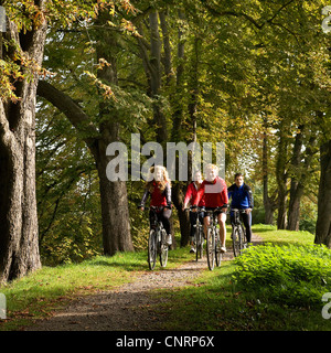 Deux jeunes couples sur des vélos sur la piste cyclable de la vallée de la Ruhr à l'avenue près de château, Allemagne, Kemnade-du-Nord-Westphalie, Ruhr, Hattingen Banque D'Images