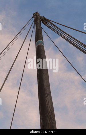 Mât en bois d'un dhow contre ciel bleu avec des nuages au coucher du soleil. Banque D'Images