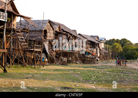 Des enfants jouent au crépuscule. Ce village est à proximité du lac Tonle Sap. Le village est aussi appelé village flottant au Cambodge. Banque D'Images