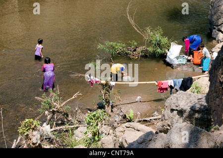 Une famille de tribus des agriculteurs sur brûlis sont à laver les vêtements dans une rivière à Pang Ma Sappong (Pha) en Thaïlande. Banque D'Images