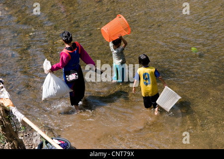 Une famille de tribus des agriculteurs sur brûlis sont à laver les vêtements dans une rivière à Pang Ma Sappong (Pha) en Thaïlande. Banque D'Images