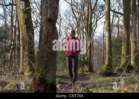 Une femme cesse de prendre dans la vue tout en marchant le West Highland Way sur les rives du Loch Lomond en Ecosse Banque D'Images